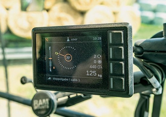 Na wyświetlaczu ustalono wartość końcową kąta nachylenia równą 20°, pasek po lewej stronie wskazuje aktualną wysokość narzędzia. Na widłach spoczywa 125 kg, łącznie w ruch wprawiany jest ciężar 440 kg.