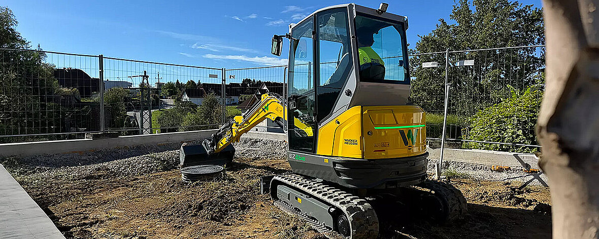 Wacker Neuson EZ26e podczas pracy na miejskim placu budowy.