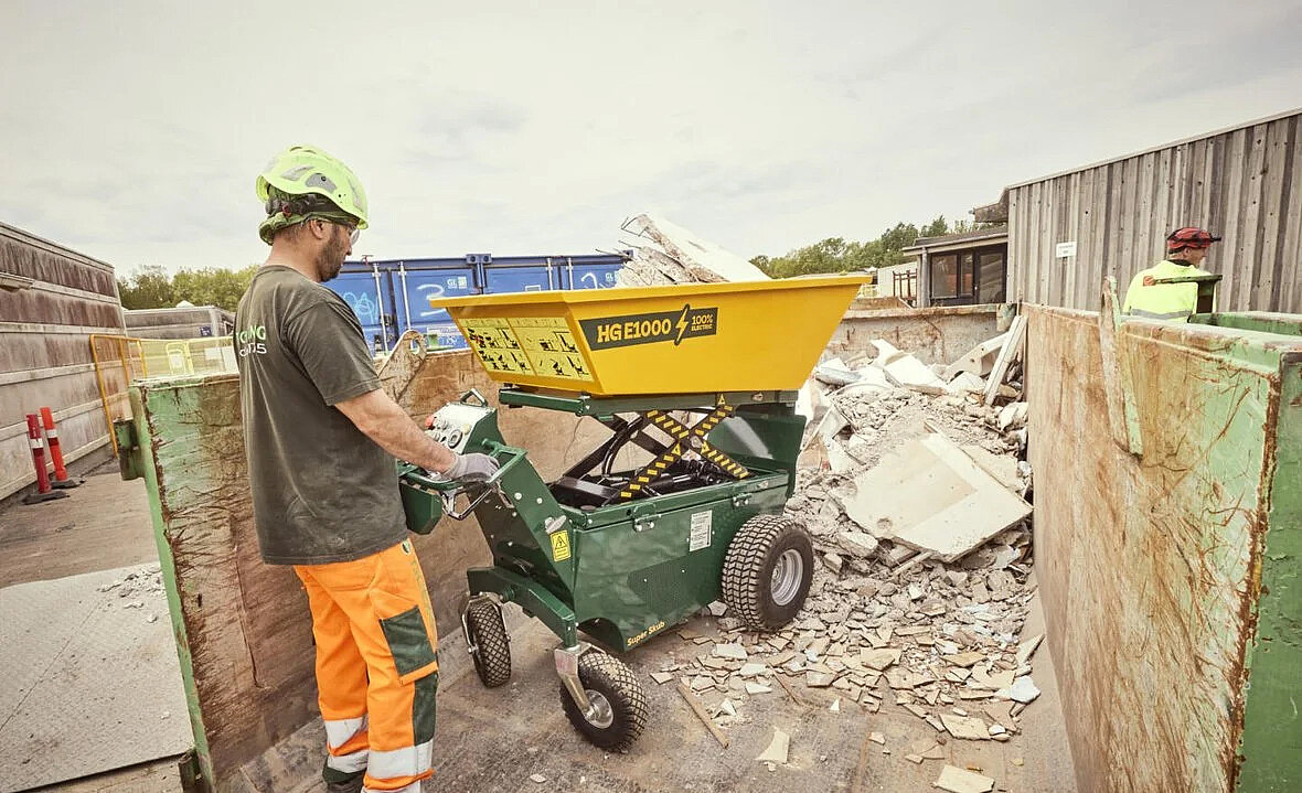 HG E1000 HT – elektryczna miniwywrotka o ładowności 1000 kg podczas transportu gruzu na placu robót.